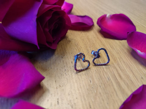 surrounded by roses are a set of sterling silver heart stud earrings