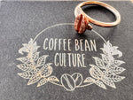 sitting on a black jewellery box sits a sterling silver ring with a red bronze coffee bean on it
