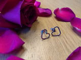 surrounded by roses are a set of sterling silver heart stud earrings