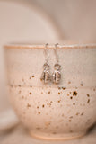 hung from the hooks are a pair of sterling silver coffee bean drop earrings