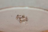 Resting on a ceramic plate sits two sterling silver coffee bean cuff links facing side on