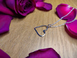 resting on it's side is a sterling silver heart necklace